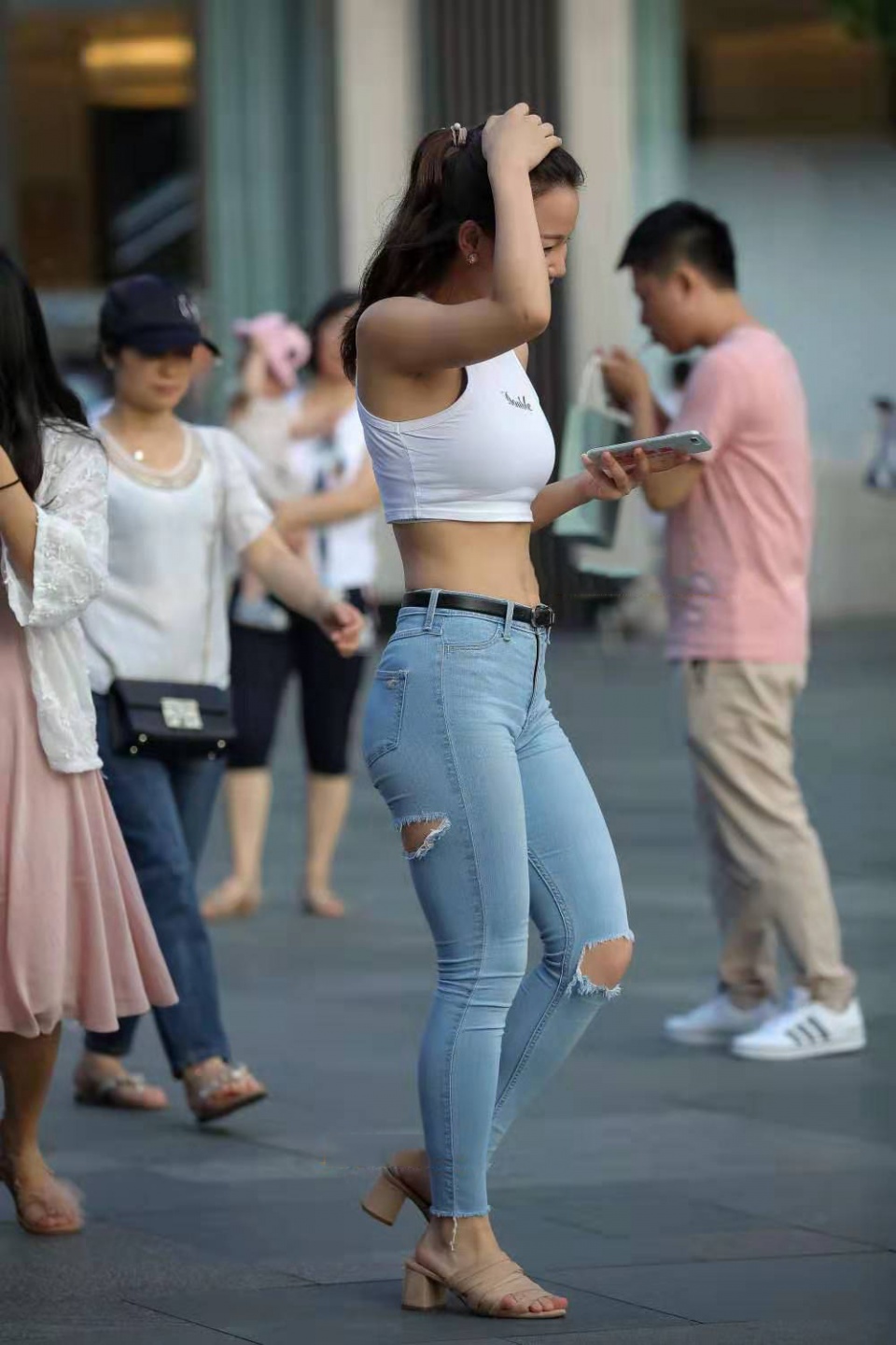 重庆街拍：身穿白色短打背心的小姐姐，尽显纤细曼妙的腰身-街拍流行馆